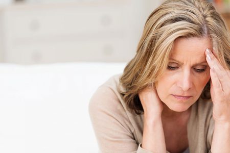 stressed woman with her hand on her forhead